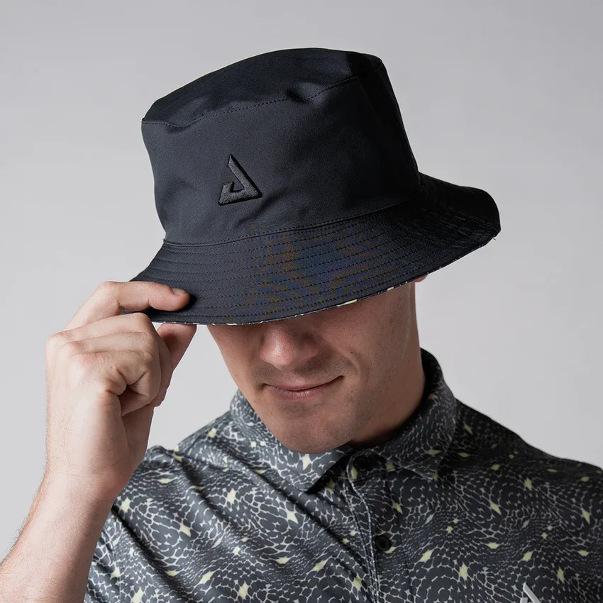 Người mẫu đội mũ JOOLA Reversible Bucket Hat ở mặt trơn, tay chỉnh vành mũ
