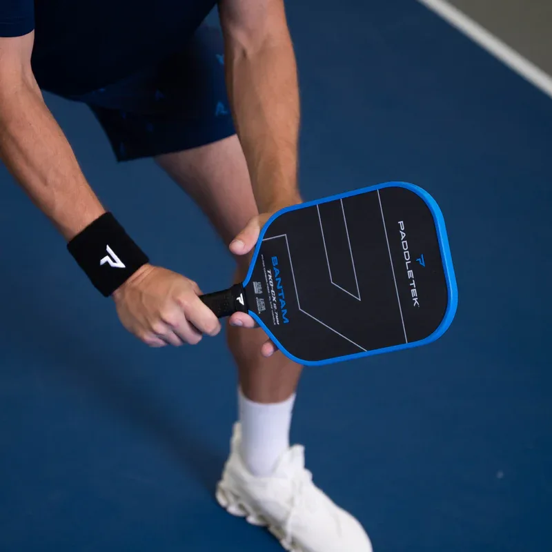 Người chơi khuỵu gối, cầm vợt Paddletek Bantam TKO-CX trước người ở tư thế sẵn sàng